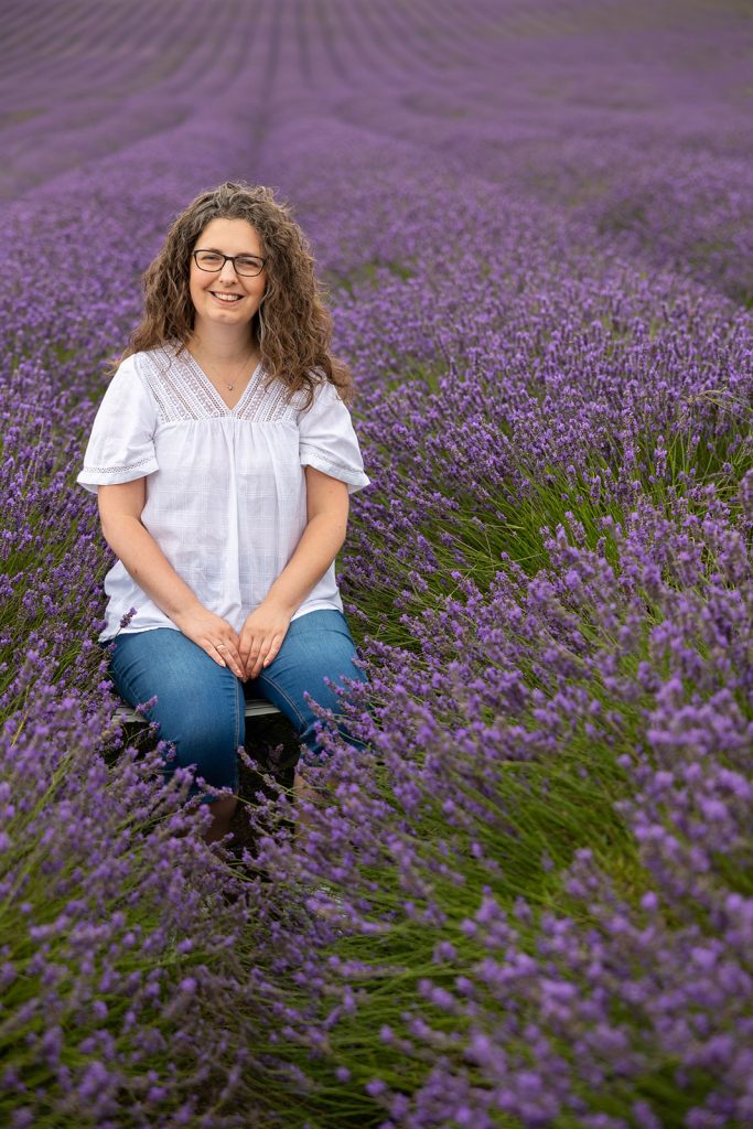 Photo of Sarah Holland sitting on a chair in a lavender field